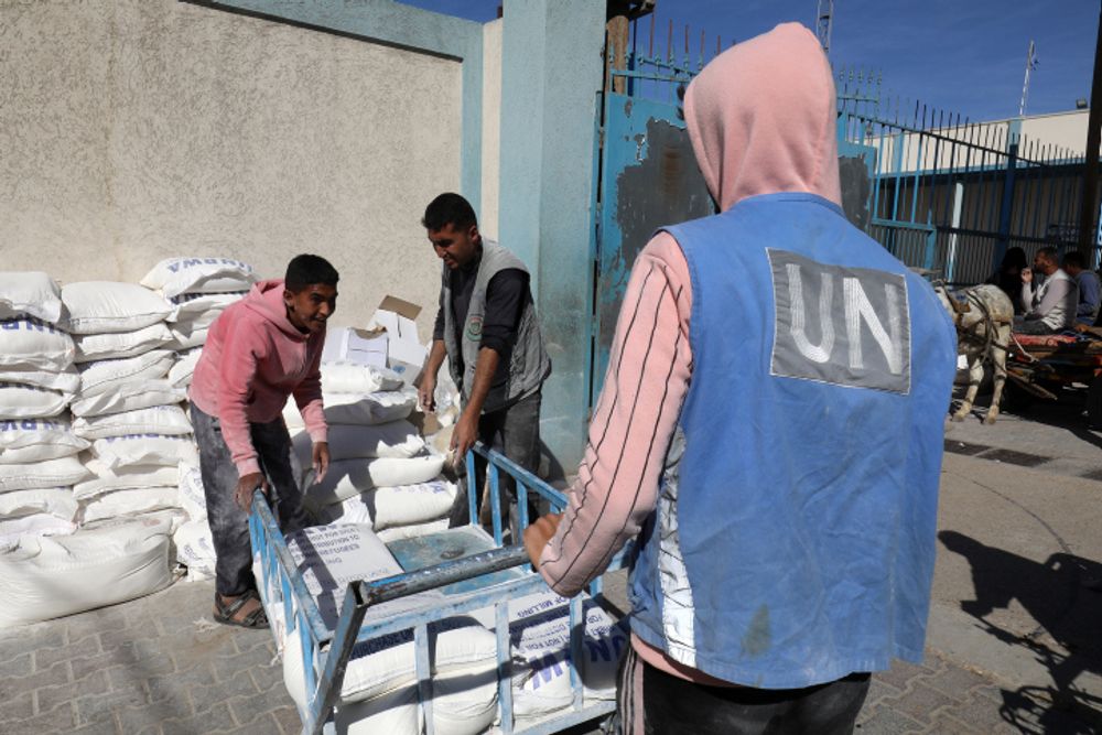 Palestinians receive food aid at a United Nations distribution center (UNRWA) in the southern Gaza Strip town of Rafah, on November 30, 2021.