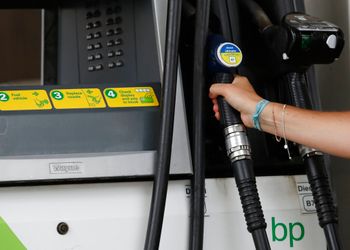 زبون يمسك بمضخة بنزين تابعة لشركة بريتيش بتروليوم (BP) في غرب لندن، الثلاثاء، 4 أغسطس 2020.