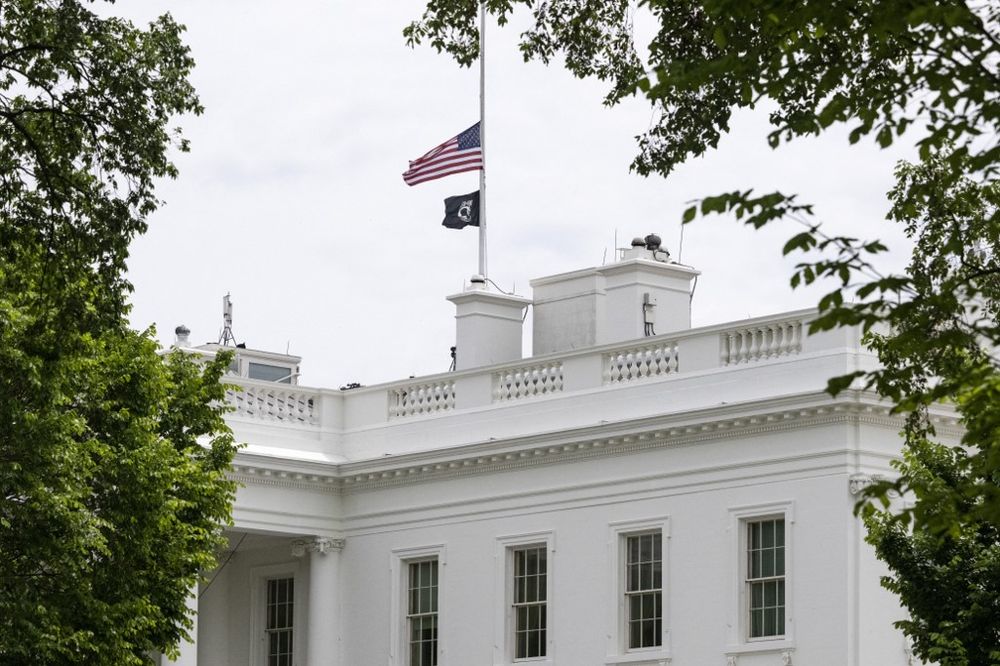 The U.S. flag flies at half staff over the White House in Washington, DC after an order from U.S. President Joe Biden honoring the victims of the shooting in Allen, Texas.