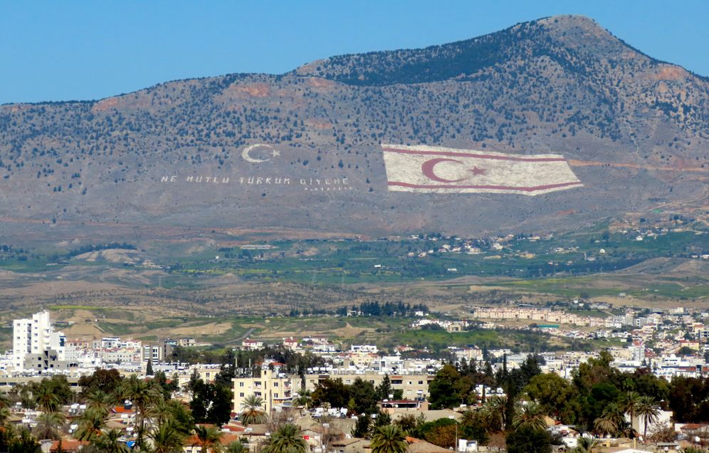 Cette photo prise le 2 février 2019 montre une vue sur la chaîne de montagnes de Kyrenia au nord de la capitale chypriote avec les drapeaux de la Turquie (L) et de la République turque de Chypre du Nord (TRNC)