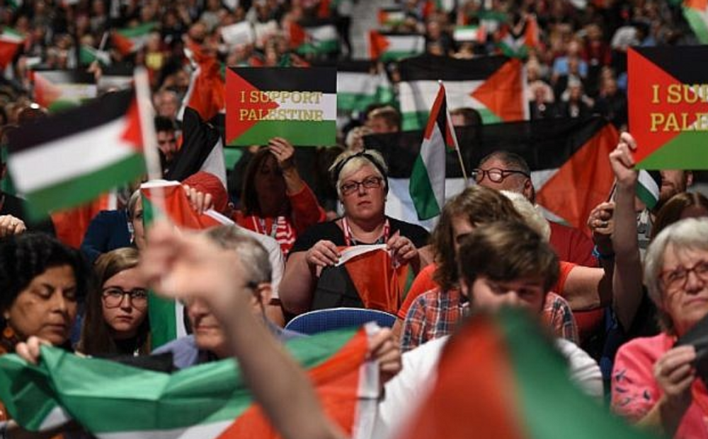 Delegates brandishing Palestinian flags at a Labour party conference in Liverpool, September 25, 2018.