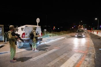 Israeli soldiers and police inspect the scene of a fatal shooting attack in Tapuach Junction, south of the West Bank city of Nablus, on May 2, 2021.