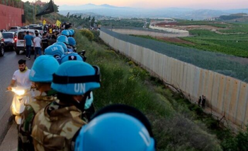 Des soldats de la force de maintien de la paix des Nations unies au Liban (FINUL) se tiennent le long du mur frontalier avec Israël, dans le village libanais d'Adaiseh, le 15 mai 2021.
