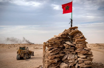 Un bulldozer passe devant une butte tenue par des soldats marocains sur une route entre le Maroc et la Mauritanie à Guerguerat situé au Sahara occidental, le 23 novembre 2020.