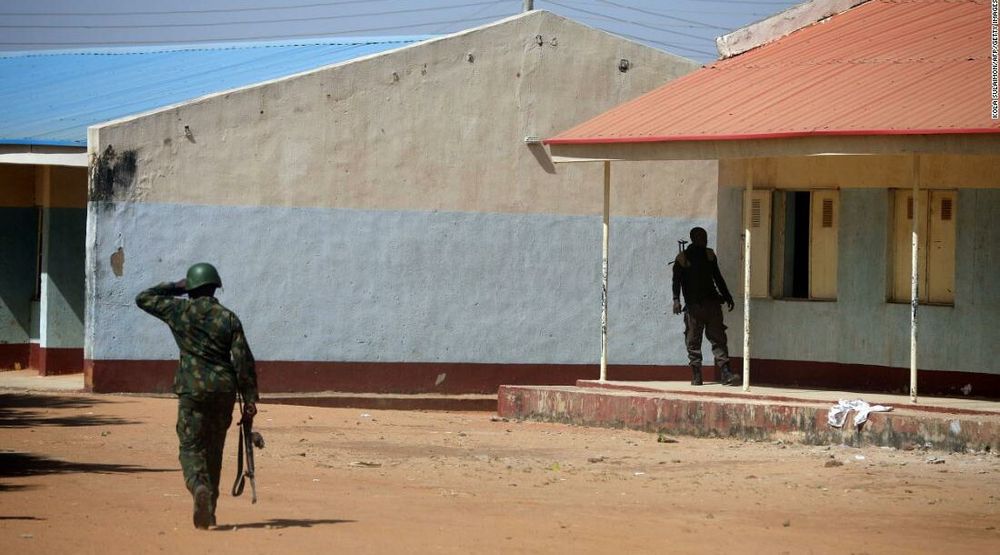 Nigerian soldiers walk inside a rural school in Kankara, Nigeria