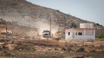Israeli settlers gather in front of Palestinian houses in the West Bank village of Qusra, south of Nablus, August 13, 2026. 