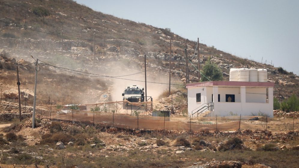 Flash90 Israeli settlers gather in front of Palestinian houses in the West Bank village of Qusra, south of Nablus, August 13, 2026.
