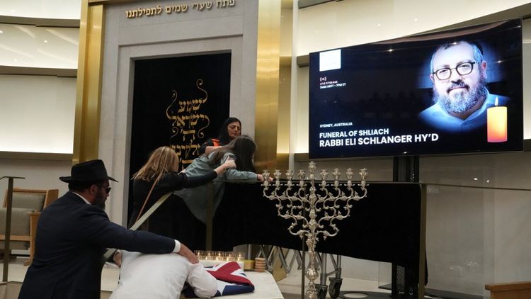 Les membres de la famille du rabbin Eli Schlanger, tué dans l'attentat de Bondi Beach, pleurent sur son cercueil lors de ses funérailles à la synagogue Habad de Bondi, à Sydney, le 17 décembre 2025