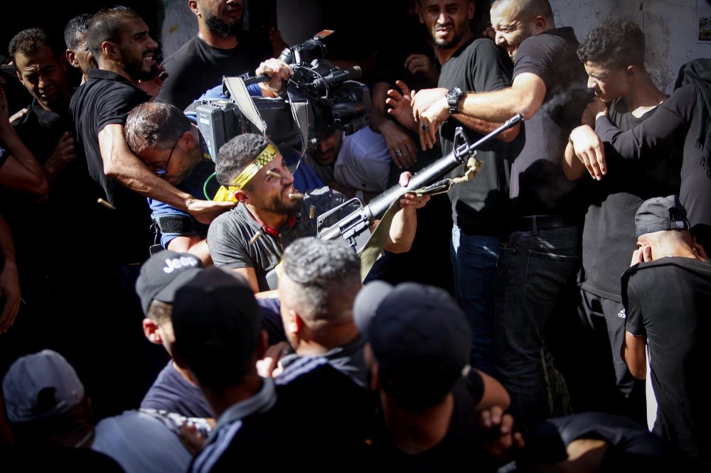 Palestinian gunmen attend the funeral of Emad Hashash, 15, who was killed during clashes with Israeli forces, in the Balata refugee camp in the West Bank, August 24, 2021.