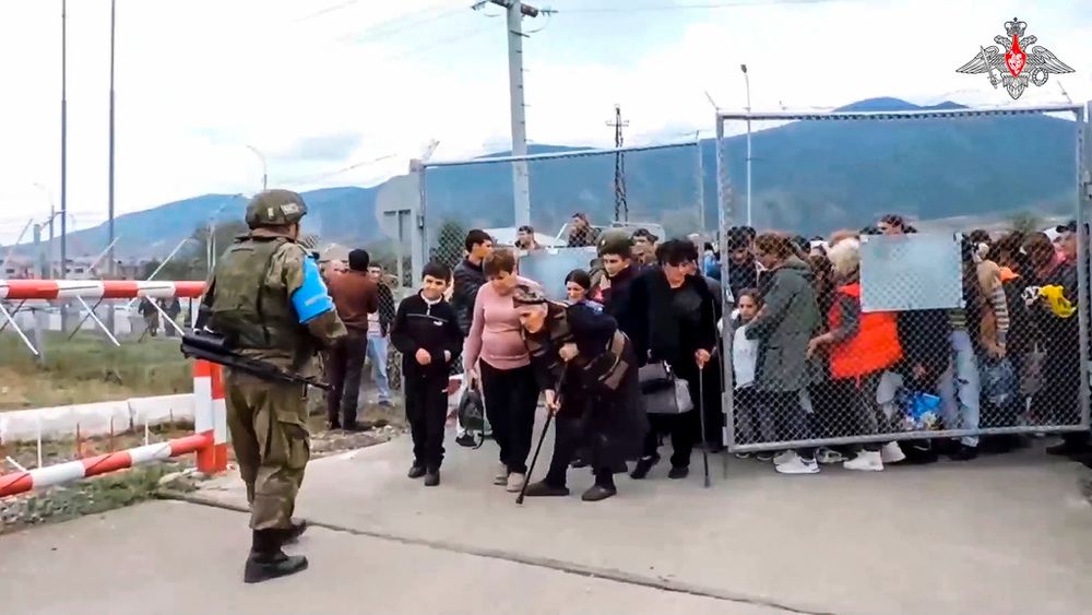 In this image made from video released by Russian Defense Ministry Press Service, a Russian peacekeeper guards a gate into a camp near Stepanakert in Nagorno-Karabakh.