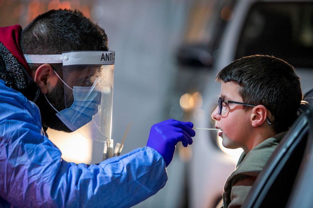 Yossi Aloni/Flash90 Health care worker takes swab samples from Israelis at a Covid-19 drive through testing complex in Modi'in, February 1, 2022.