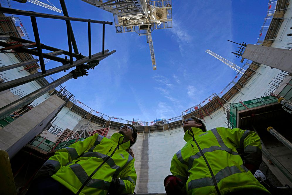 (AP Photo/Kin Cheung, File) FILE - Employees look up at the construction site of Hinkley Point C nuclear power station in Somerset, England, Tuesday, Oct. 11, 2022