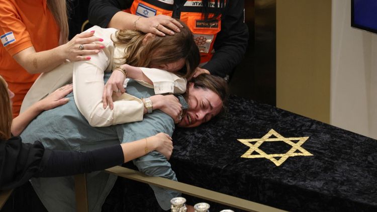 Les membres de la famille du rabbin Eli Schlanger, tué dans l'attentat de Bondi Beach, pleurent sur son cercueil lors de ses funérailles à la synagogue Habad de Bondi, à Sydney, le 17 décembre 2025