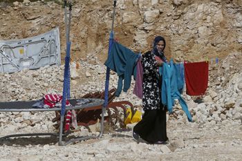A woman hangs laundry on a clothesline in the Bedouin village of Tel Arad in Israel's Negev desert, on February 24, 2021.