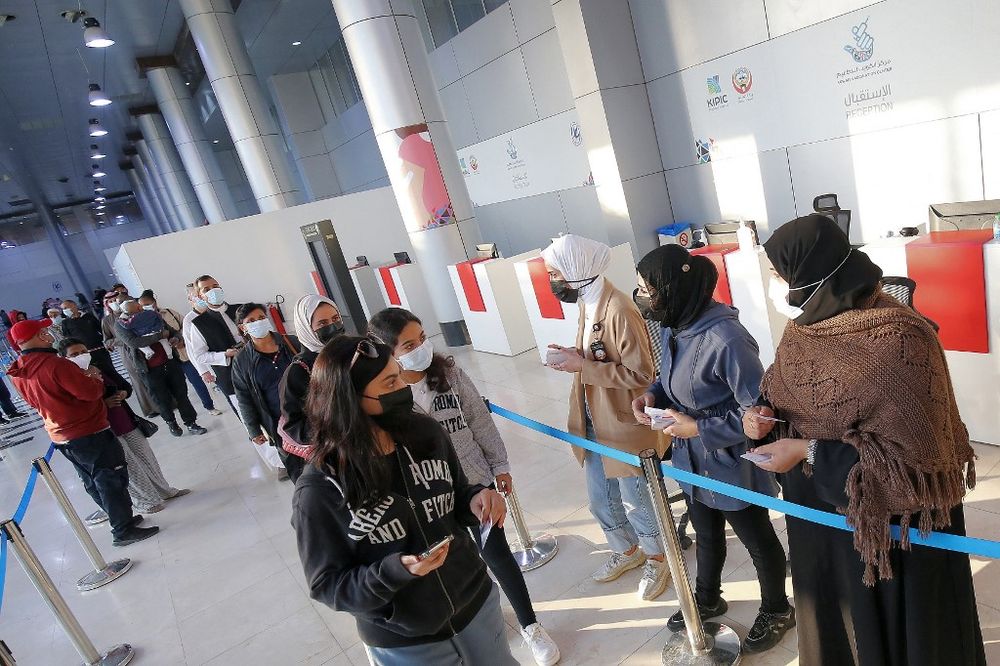People are directed towards vaccination booths as they arrive to receive Covid vaccine booster doses at the Kuwait International Fairground in Kuwait City, Kuwait, on January 3, 2022.