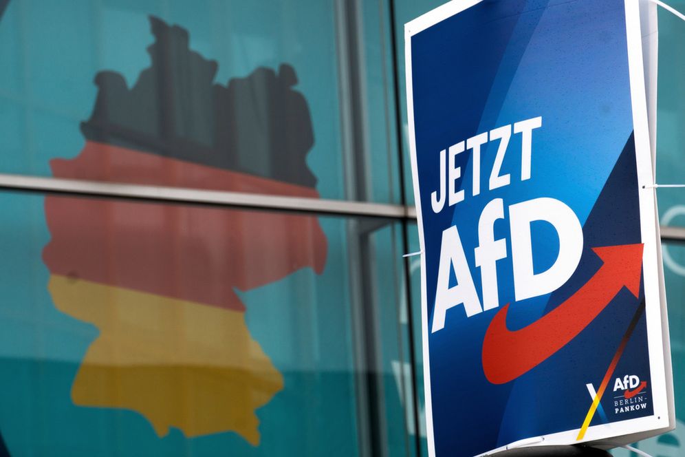 ملصق انتخابي لحزب البديل من أجل ألمانيا (AfD) اليميني المتطرف الألماني، مُعلق على عمود إنارة أمام ملصق انتخابي ضخم يُظهر خريطة ألمانيا، في مقر الاتحاد الديمقراطي المسيحي الألماني (CDU) في برلين، ألمانيا، 29 يناير/كانون الثاني 2025. الشعار يقول: "الآن حزب البديل من أجل ألمانيا".