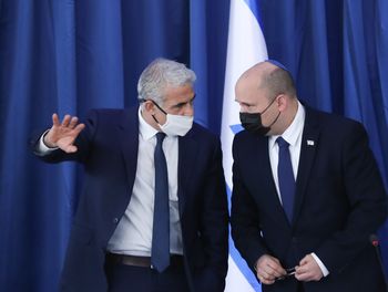 Israel's Prime Minister Naftali Bennett (left) speaks with Alternate Prime Minister and Foreign Minister Yair Lapid at the Ministry of Foreign Affairs in Jerusalem on August 8, 2021.