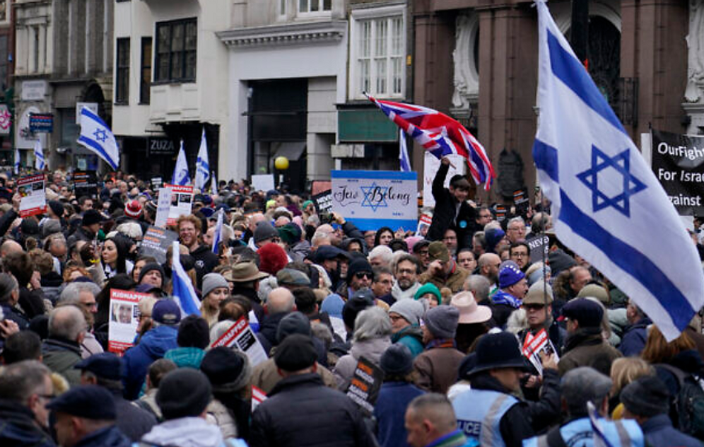 AP Photo/Alberto Pezzali Illustration - Des manifestants brandissent des pancartes, des drapeaux et des banderoles lors d'un rassemblement contre l'antisémitisme à Londres, le 26 novembre 2023.