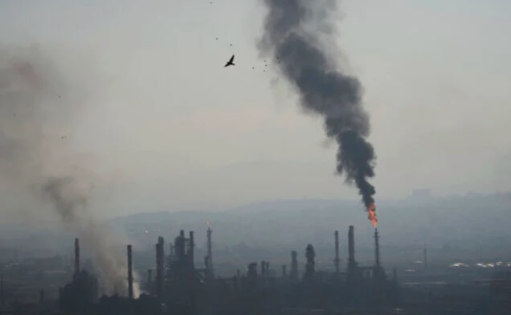 AP/Ariel Schalit Des panaches de fumée s'échappent de la raffinerie de pétrole Bazan à Haïfa, dans le nord d'Israël, après un tir de missile iranien tôt le 16 juin 2025.