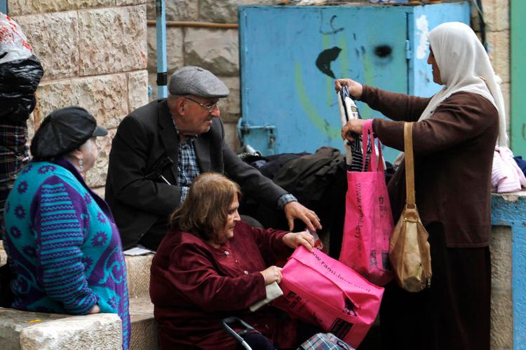 امرأة عربية تتفقد الملابس المعروضة للبيع في سوق محانيه يهودا في القدس. 14 نوفمبر 2011.