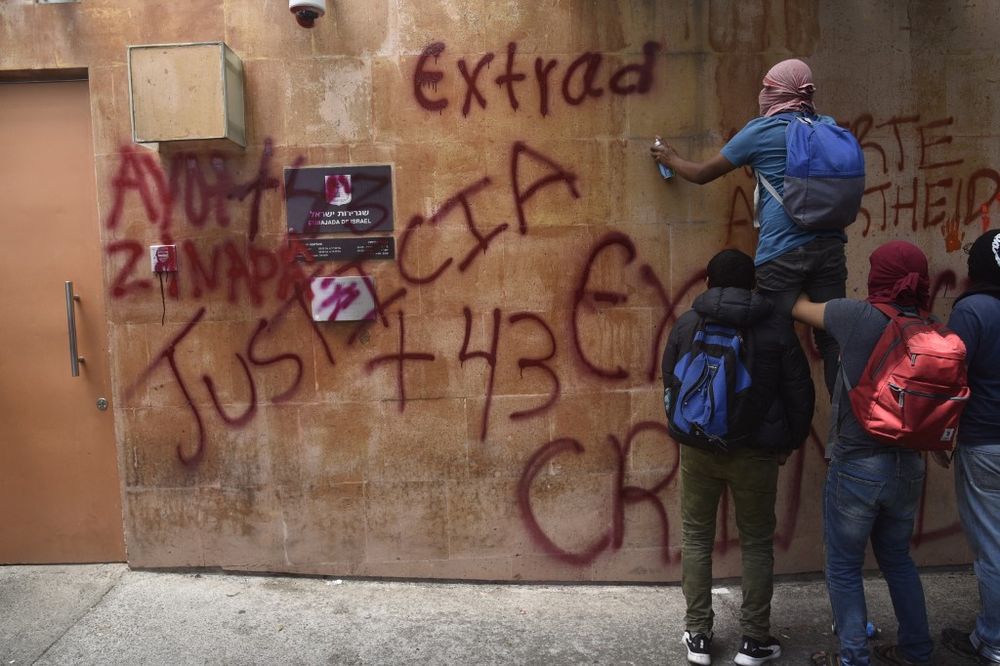 Students from Ayotzinapa paint slogans on the walls of the Israeli embassy in Mexico City, Mexico, during a demonstration on September 21, 2022, to demand the extradition of former attorney general Tomas Zeron.