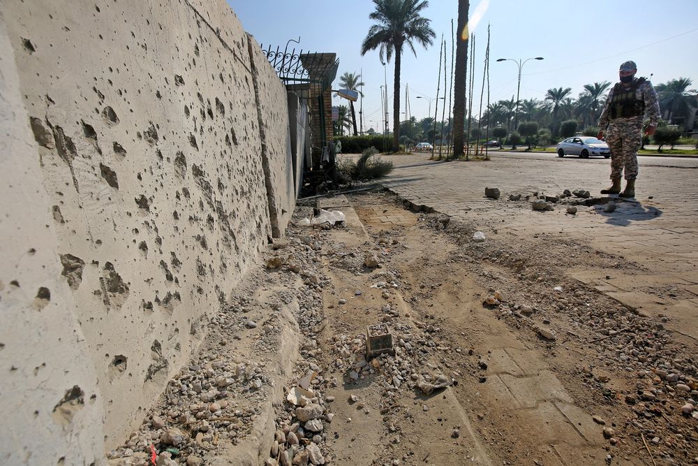 FILE - A member of the Iraqi security forces inspects the damage outside the Zawraa park in the capital Baghdad, on November 18, 2020, after a volley of rockets slammed into the Iraqi capital.