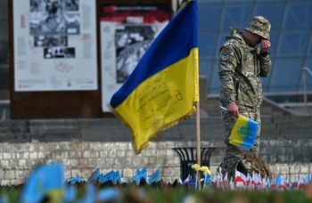 A serviceman mourns next to a Ukrainian flag at a makeshift memorial for fallen soldiers at Independence Square in Kyiv, on November 10 2023, amid the Russian invasion of Ukraine.