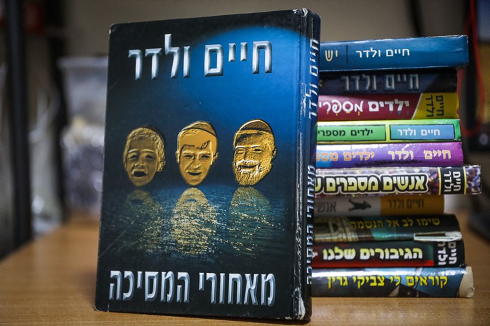 Ultra-Orthodox children's author Chaim Walder books on a shelf at a home of an ultra-Orthodox Jewish family in Jerusalem, December 31, 2021.
