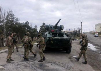 Ukraine's Security Service special forces troops standing past a tank during a large-scale anti-terrorism exercise in Kherson region of the country on April 14, 2021.