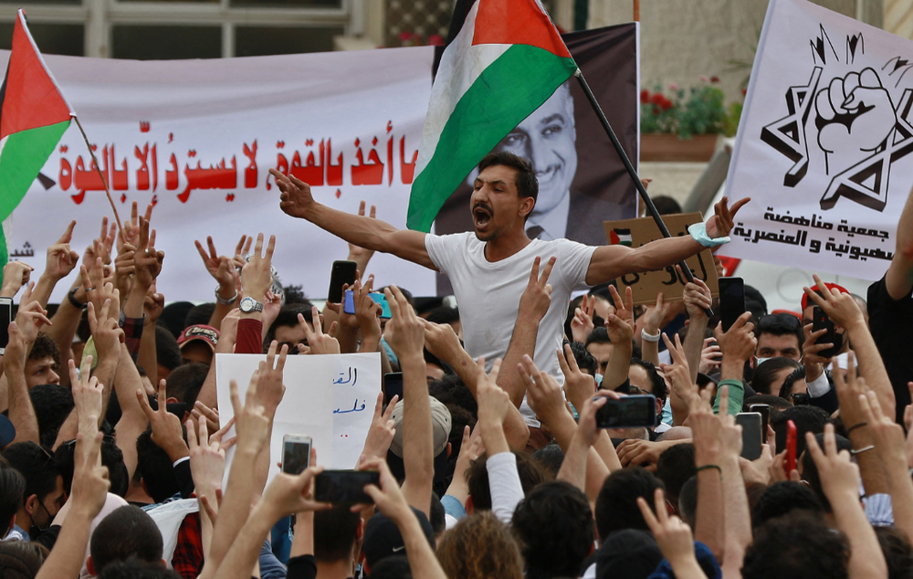 Les gens scandent des slogans alors qu'ils se rassemblent pour une manifestation pour exprimer leur solidarité avec le peuple palestinien près de l'ambassade d'Israël à Amman, la capitale de la Jordanie, le 9 mai 2021.