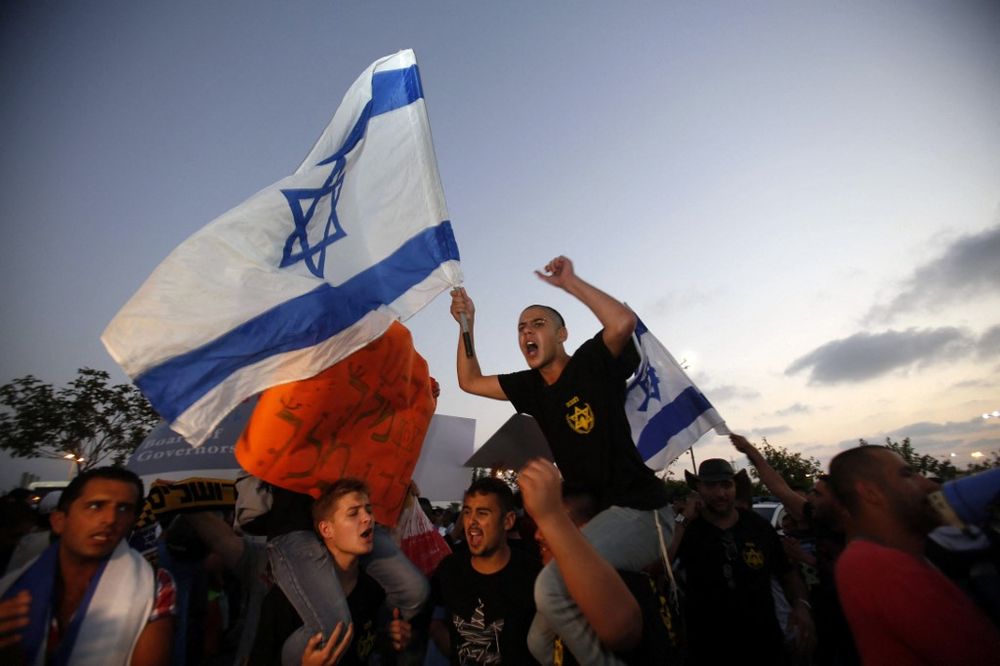 Ministros israelenses pedem para proibir a extrema-direita Lehava e La Familia Apoiadores israelenses do grupo de direita Lehava cantam slogans do lado de fora do salão de casamento onde um árabe-israelense e uma judia se casaram em 17 de agosto de 2014 na cidade costeira israelense de Rishon LeZion.