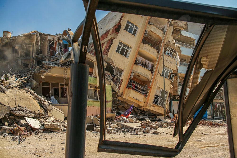 A building destroyed by an earthquake leans on a neighboring house in Samandag, southern Turkey.