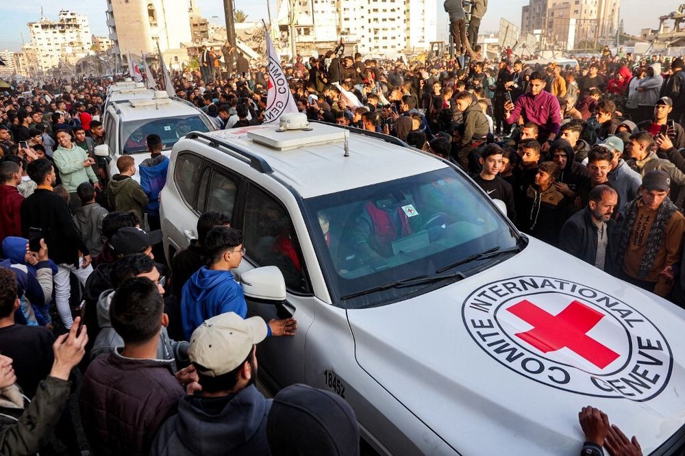 Des gens se rassemblent autour d'un véhicule du Comité international de la Croix-Rouge (CICR) sur la place Saraya, dans l'ouest de la ville de Gaza, le 19 janvier 2025