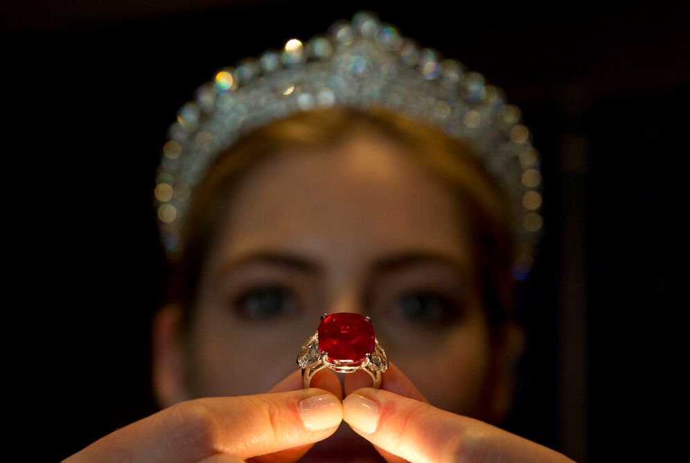 An employee of Sotheby's auction house holds up the 'Sunrise Ruby' ring in London, England.