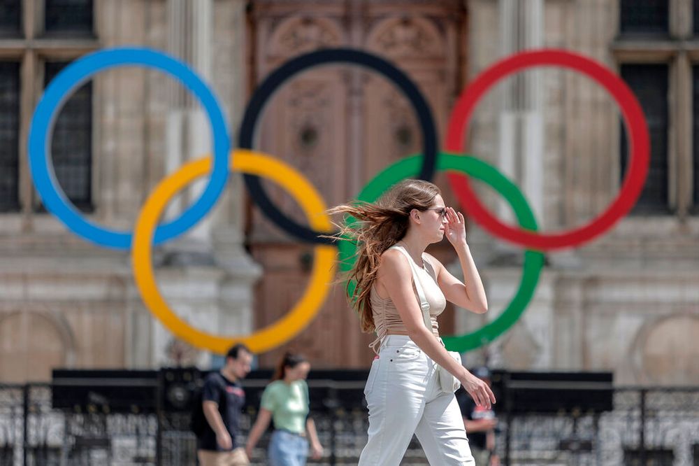 A woman passes by the Olympic rings in Paris, France.