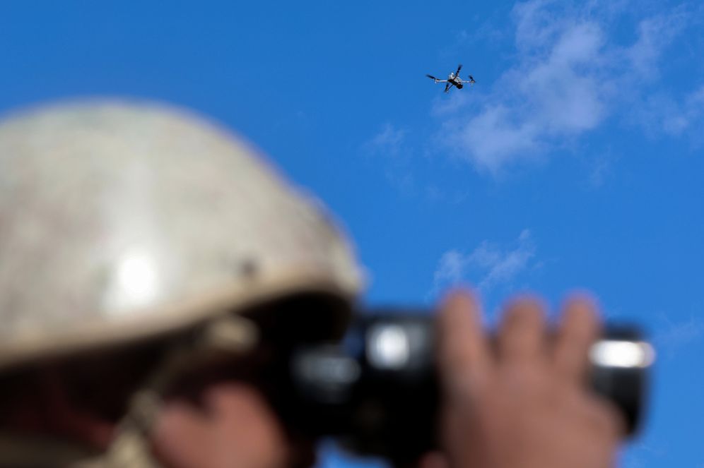 AP Photo/Raad Adayleh A Jordanian border guard uses binoculars as a drone flies above during training exercises focused on countering drug smuggling attempts near Al Shajara village, along Jordan's northern border with Syria, Sunday, Oct. 4, 2026.