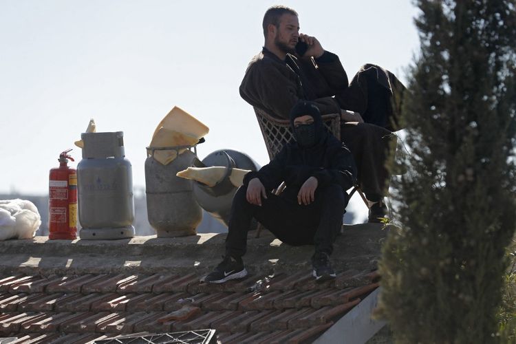 Members of the Palestinian Salhiya family sit on the roof of their home as they protest their eviction by Israeli Police and the Jerusalem municipality, on January 18, 2022 in Jerusalem's east district of Sheikh Jarrah.