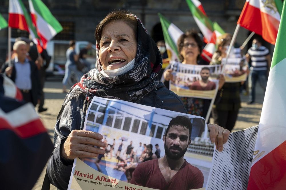 A woman holds a portrait of Iranian wrestler Navid Afkari during a demonstration on the Dam Square in Amsterdam, the Netherlands, on September 13, 2020.