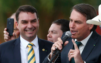 Le sénateur brésilien Flavio Bolsonaro, à gauche, regarde son père, alors président Jair Bolsonaro, lancer un nouveau parti politique, l'Alliance pour le Brésil, à Brasilia, au Brésil, le 21 novembre 2019. 