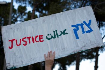A Israeli woman holds a placard that reads, "justice," in English, Farsi and Hebrew during a protest in solidarity with Mahsa Amini in Jerusalem.
