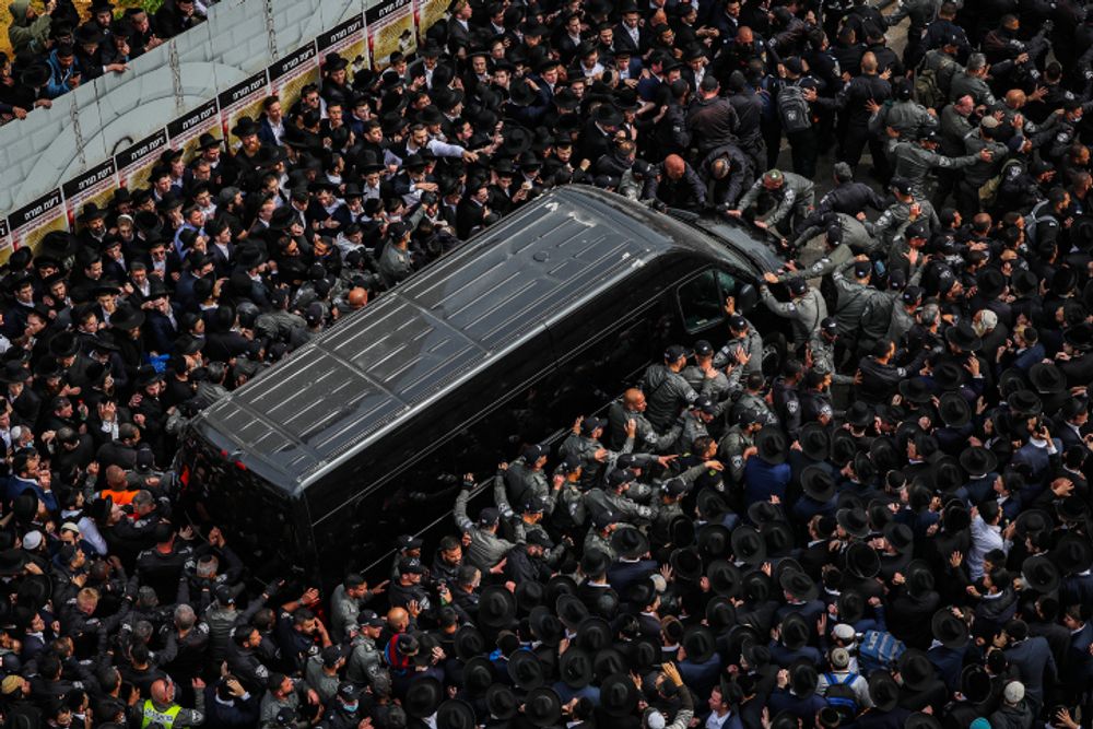 Des membres de la communauté ultraorthodoxe se pressent autour du véhicule transportant la dépouille du rabbin Kanievski à Bnei Brak, le 20 mars 2022