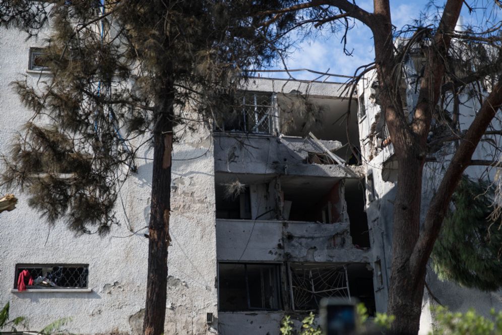 Workers clean up by the apartment building that was hit by a rocket fired from the Gaza Strip in the southern Israeli city of Ashkelon, on November 13, 2018.