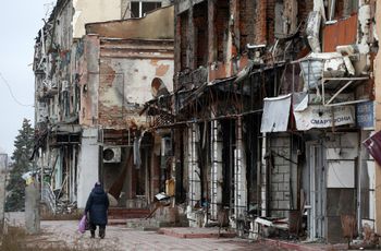 A local resident walks past heavily damaged buildings in the town of Izyum, Kharkiv region, Ukraine, on November 25, 2022, amid the Russian invasion of Ukraine.