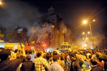 Egyptians gather as firefighters extinguish a fire on a church after clashes between Muslims and Christians in Cairo, Egypt, on May 7, 2011.
