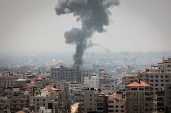 Smoke rises above buildings After air strikes by Israeli warplanes in Gaza City