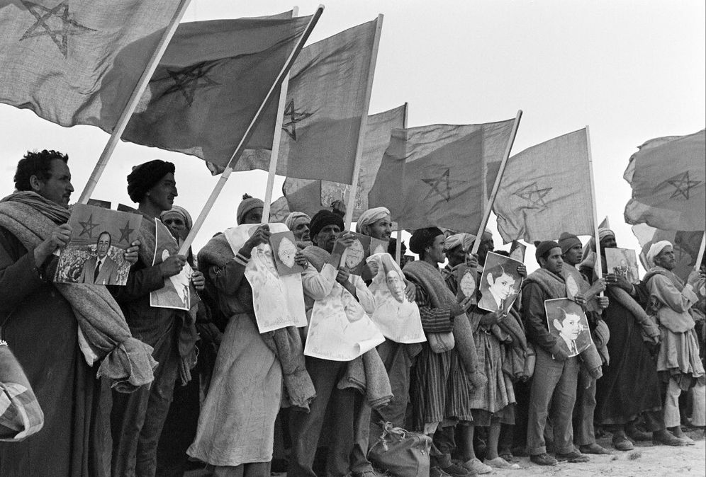 شارك المتطوعون المغاربة في المسيرة الخضراء بستائر وصور لملك الحسن الثاني، في 07 نوفمبر 1975، في مخيم طرفاية، في طريقهم عبر الحدود الإسبانية للصحراء