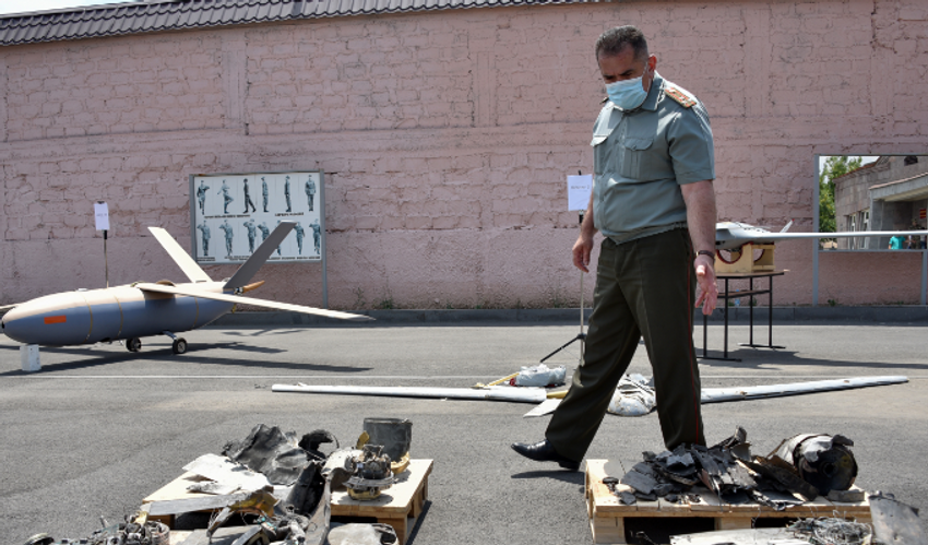 Un officiel marche parmi des objets que l'Arménie a présentés comme des drones azéris détruits lors de récents affrontements armés à la frontière arméno-azerbaïdjanaise, à Erevan le 21 juillet 2020.