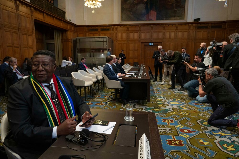 Ambassador of the Republic of South Africa to the Netherlands Vusimuzi Madonsela, left, wait while journalists take images of Israel legal team, rear, before Judges entered the International Court of Justice in The Hague, Netherland