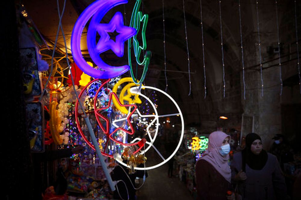 Palestinian women walk past decorative lights set up for the holy Muslim month of Ramadan, in Jerusalem's Old City, April 12, 2021.