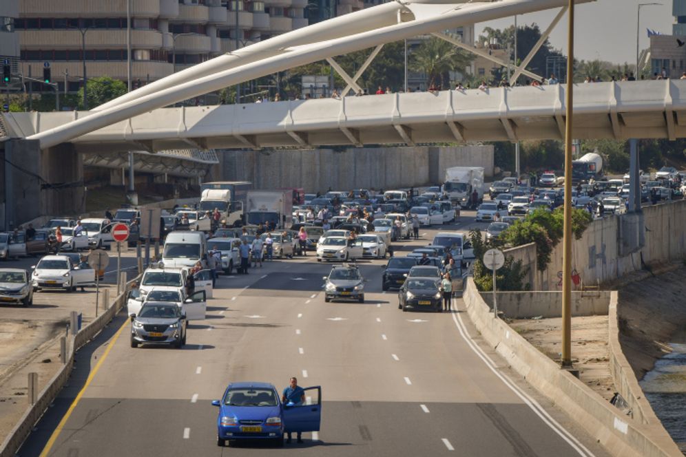 Des Israéliens sortent de leurs véhicules sur l'autoroute Ayalon à Tel Aviv au son de la sirène de Yom HaShoah, le 18 avril 2023